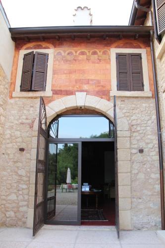 Relais Villa Ambrosetti في فيرونا: مدخل لمبنى من الطوب مع باب مفتوح