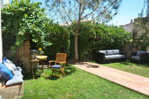 a garden with a couch and a table and chairs at Hotel Casa Calella in Calella de Palafrugell
