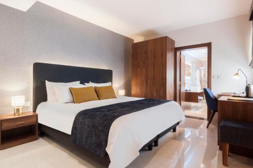 a bedroom with a large bed and a desk and a bed sidx sidx at The Duke Boutique Hotel in Victoria