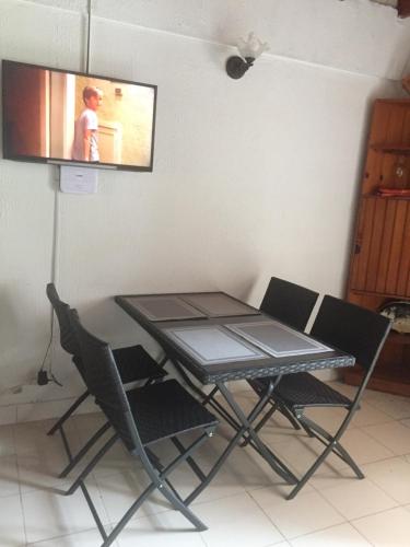 een tafel en stoelen met een televisie aan de muur bij Apartamento Duplex Unisanandres in San Andrés