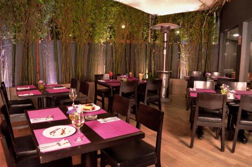 a dining room with tables and chairs with pink napkins at LaiLa Hotel CDMX Reforma in Mexico City