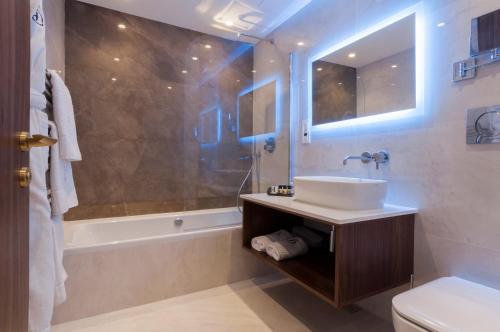a bathroom with a sink and a tub and a toilet at The Duke Boutique Hotel in Victoria