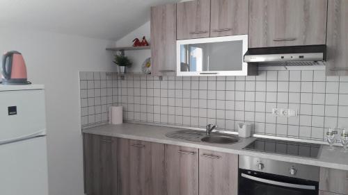 a kitchen with wooden cabinets and a sink at Vila Rosa in Sevid