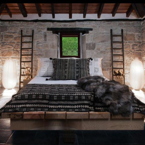 a bedroom with a large bed in a stone wall at Molino Tejada in Polientes