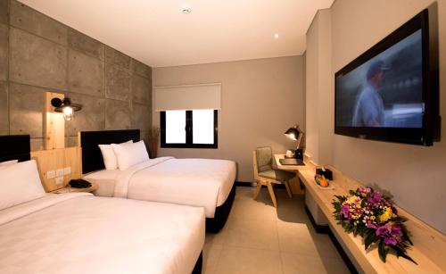 
A bed or beds in a room at Ayaartta Hotel Malioboro
