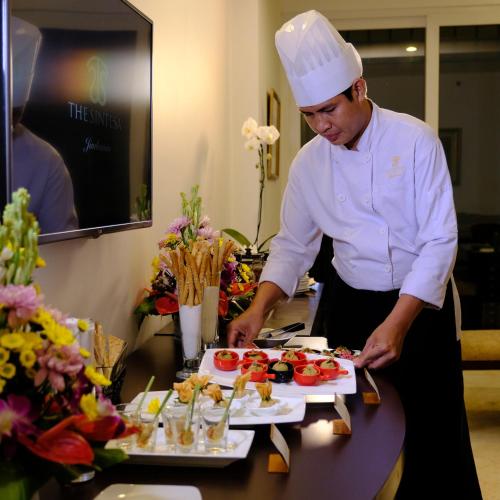 a chef is preparing food on a table at The Sintesa Residence Jimbaran in Jimbaran