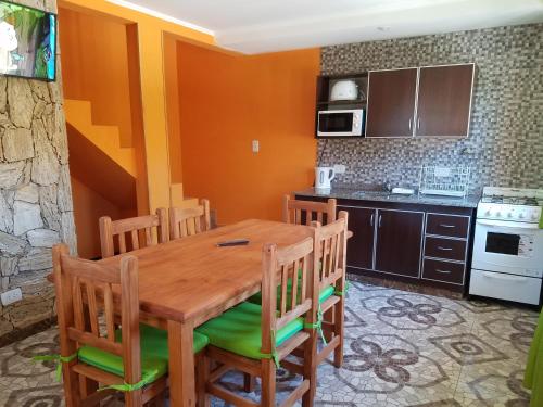 a kitchen with a wooden table and chairs at Arbolada Talas del Tuyu in San Clemente del Tuyú