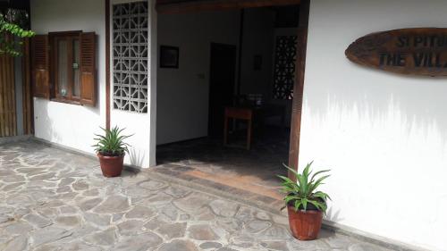 two potted plants are sitting outside of a building at Si Pitung Village in Gili Air
