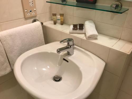 a white sink in a bathroom with towels at Pacific Harbour Motor Inn in Gisborne