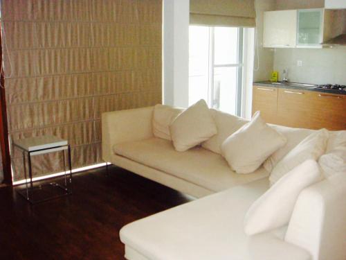 ein Wohnzimmer mit einem weißen Sofa und einer Küche in der Unterkunft Luxurious 2BHK for Ultimate Holiday Experience in Goa, Candolim North Goa in Candolim