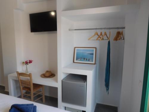 a room with a bed and a desk and a tv at Ifestia Hotel in Kamari