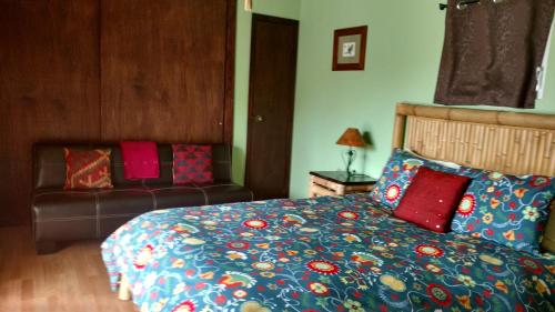 a bedroom with a bed and a couch at Vinofilia Wine Country Inn in Valle de Guadalupe