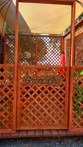 a wooden fence with a gate with a sign on it at Vinofilia Wine Country Inn in Valle de Guadalupe