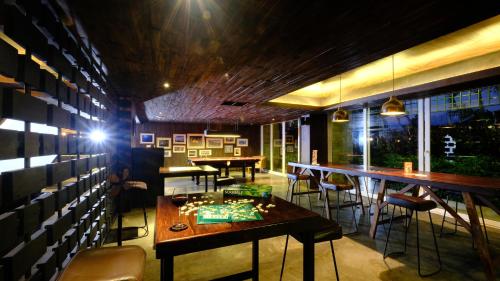 a dining room with tables and chairs and lights at The Sintesa Residence Jimbaran in Jimbaran