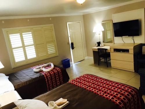 a hotel room with two beds and a desk at Apollo Inn - Cocoa in Cocoa