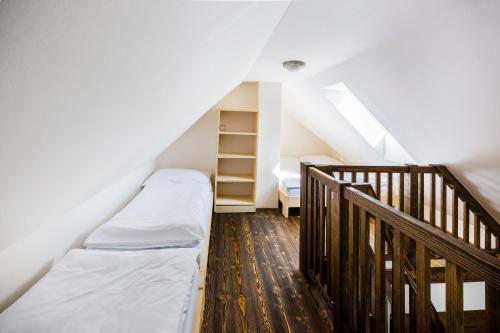a attic room with a bed and a staircase at Penzion U Barana in Trojanovice