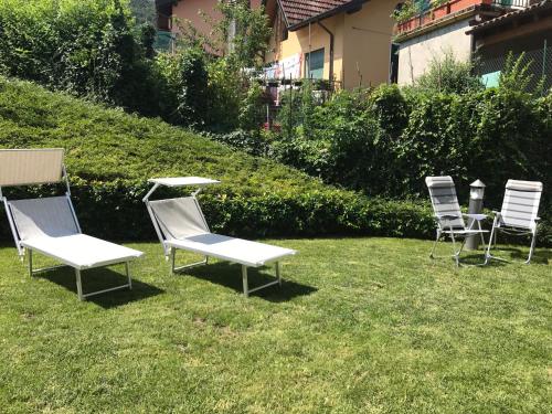 a group of lawn chairs sitting in the grass at Orchidea Apartment in Bellagio