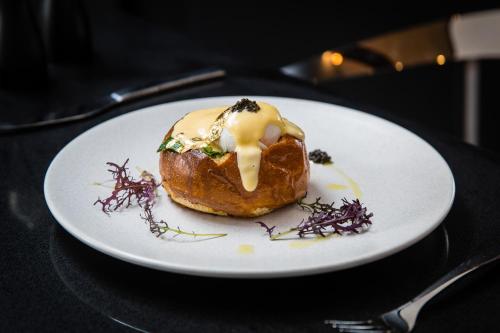 a doughnut on a white plate on a table at Pullman Sydney Airport in Sydney