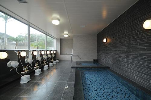 een grote badkamer met een zwembad in een gebouw bij Hotel Lexton Tanegashima in Nishinoomote