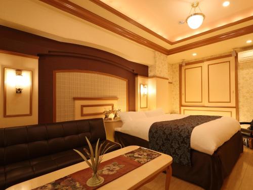 大阪市にあるHotel Fine Garden Umedaのベッドとソファ付きのホテルルーム