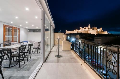 a balcony with tables and chairs and a view of a castle at The Duke Boutique Hotel in Victoria