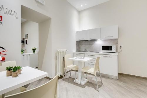 a kitchen with white cabinets and a table and chairs at Vaticano 38 Suites in Rome