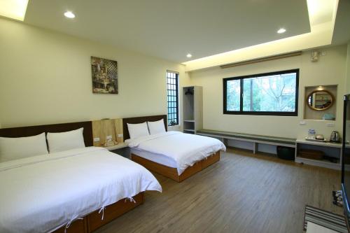 鹿谷的住宿－鋐洋民宿，一间卧室设有两张床和窗户。