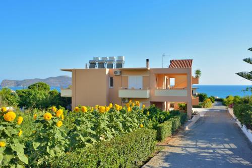 a house next to a field of sunflowers at Sofoklis Apts in Stalos