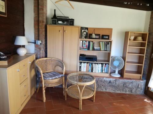 a room with two chairs and a table and a book shelf at Villa Paradisino in Orbetello