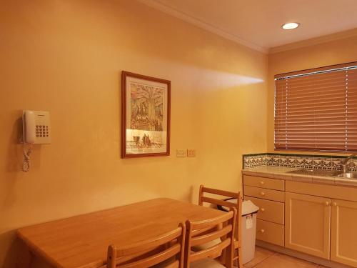 a kitchen with a wooden table and a sink at Sophia Suites Residence Hotel in Cebu City