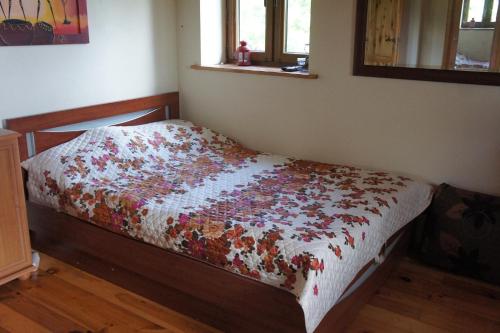 a bedroom with a bed with a quilt on it at Dom Wilków in Leoncin