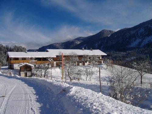 a house in the snow with a snow covered road at Bichlhof Riedenberg in Thiersee