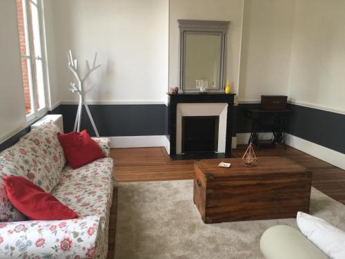 a living room with a couch and a fireplace at Le Recommandé in Avize