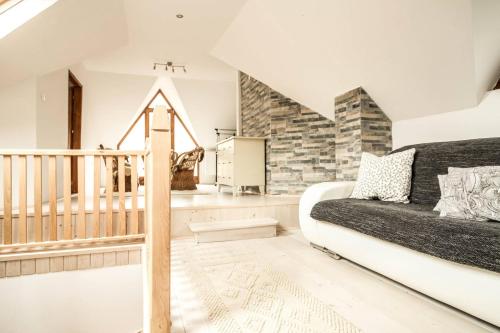 ein Wohnzimmer mit einem Sofa und einer Treppe in der Unterkunft Szőcs-birtok Apartments in Izvoare