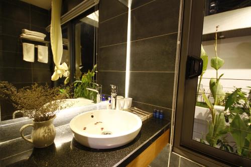 La salle de bains est pourvue d'un lavabo blanc et d'un miroir. dans l'établissement John Boutique Villa, à Đà Nẵng