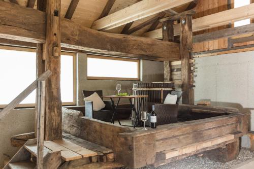 sala de estar con vigas de madera, sofá y sillas en Weinberg Lodge - Presshaus, en Klöchberg