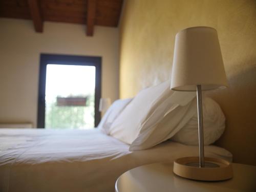 a bedroom with a bed with a lamp on a table at Quattrocolli B&B in Quattro Castella