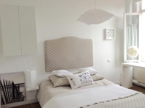 um quarto com uma cama com uma cabeceira em bolinhas em La Maison de famille les Alizés em Le Crotoy