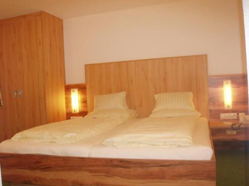 a bedroom with two beds with white sheets at Hotel Gundolf in Sankt Leonhard im Pitztal