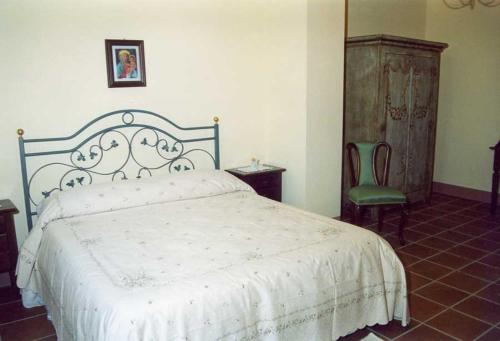 een slaapkamer met een wit bed en een groene stoel bij Agriturismo Martone in Rocca San Felice