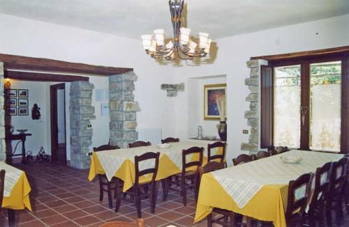 een eetkamer met tafels en stoelen en een stenen muur bij Agriturismo Martone in Rocca San Felice
