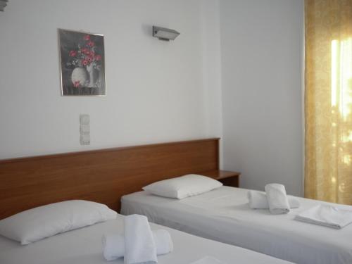 two beds in a room with two white pillows at Hotel Ritsa in Kamena Vourla