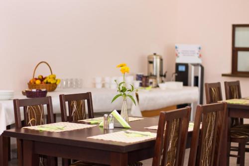 une salle à manger avec des tables, des chaises et une table avec des fleurs dans l'établissement Pokoje Gościnne w Centrum Kultury Wsi Polskiej, à Wierzchoslawice