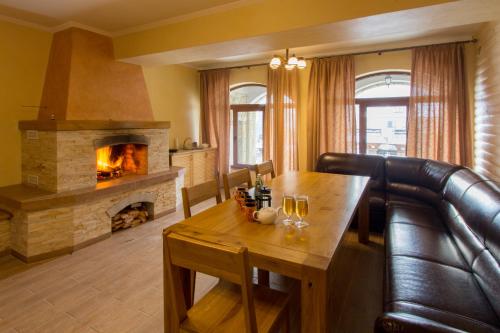 a living room with a table and a fireplace at Knyazhyj Dvir in Yaremche