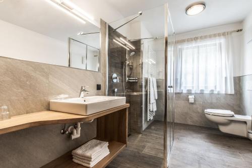 W łazience znajduje się umywalka, toaleta i prysznic. w obiekcie Pensione Camoscio w mieście La Villa