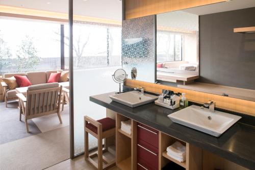 un bagno con due lavandini e un grande specchio di Hotel Granvia Hiroshima a Hiroshima