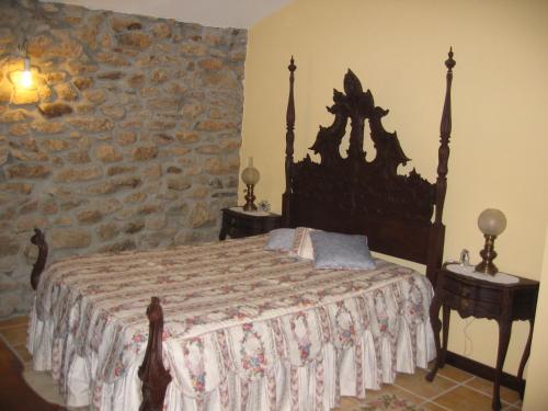 um quarto com uma cama e uma parede de pedra em Rústica para Férias em Mirandela