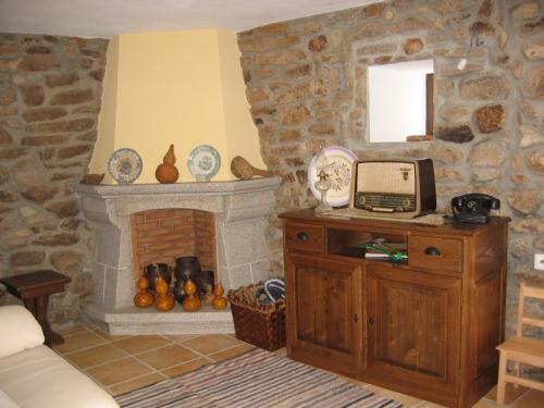 a living room with a stone wall with a fireplace at Rústica para Férias in Mirandela