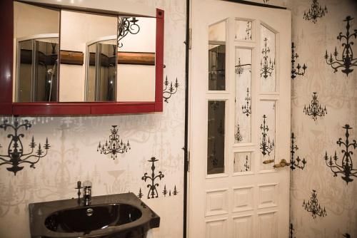a bathroom with a sink and a mirror and a door at Grenlanda in Ulanów