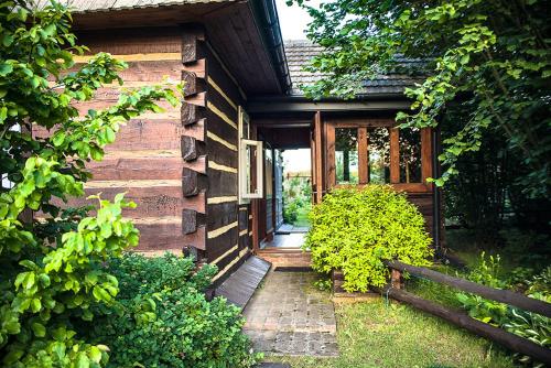 a wooden house with a pathway leading to the door at Grenlanda in Ulanów